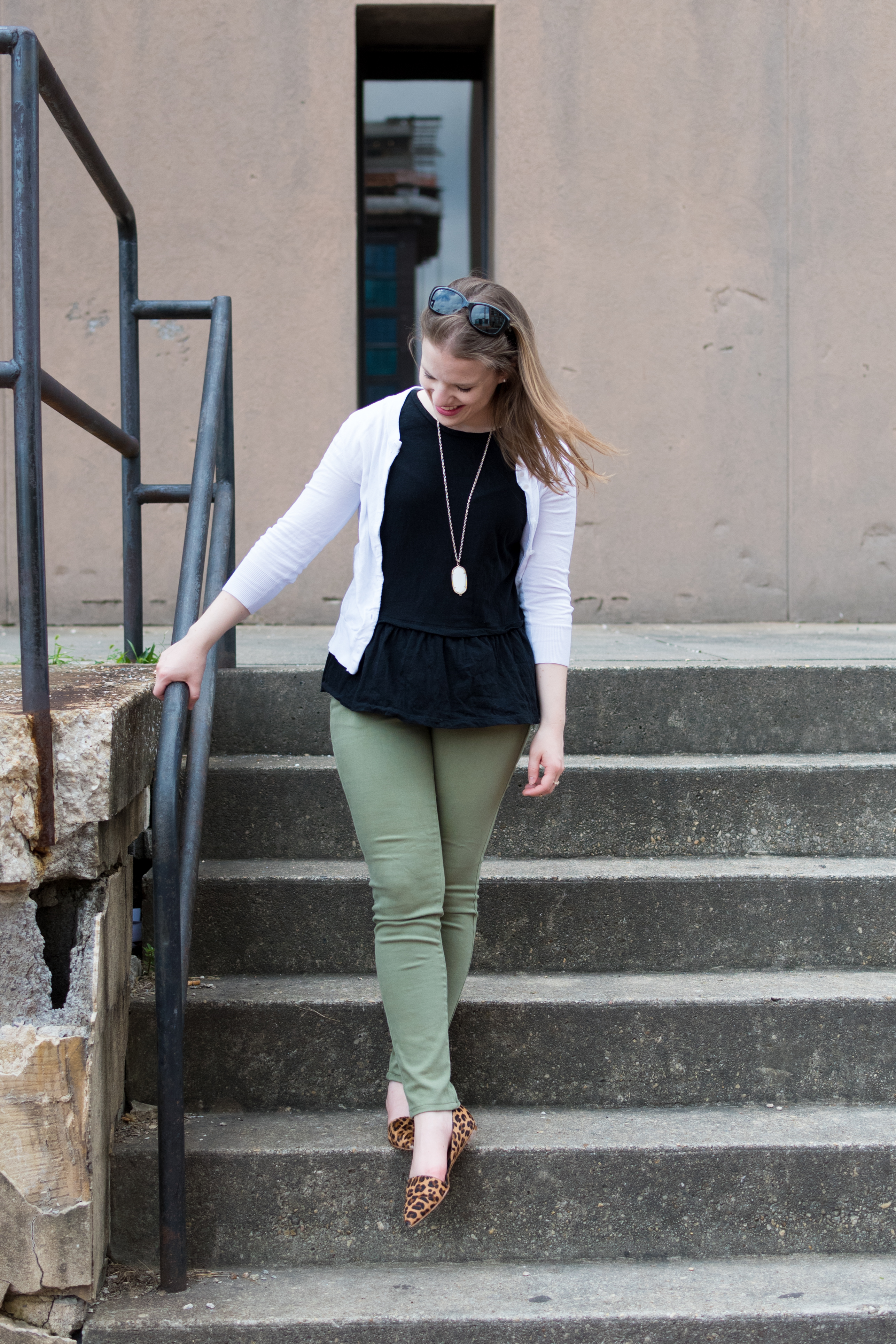 woman blogger wearing green skinny jeans and leopard print mules woman blogger wearing green skinny jeans and leopard print mules