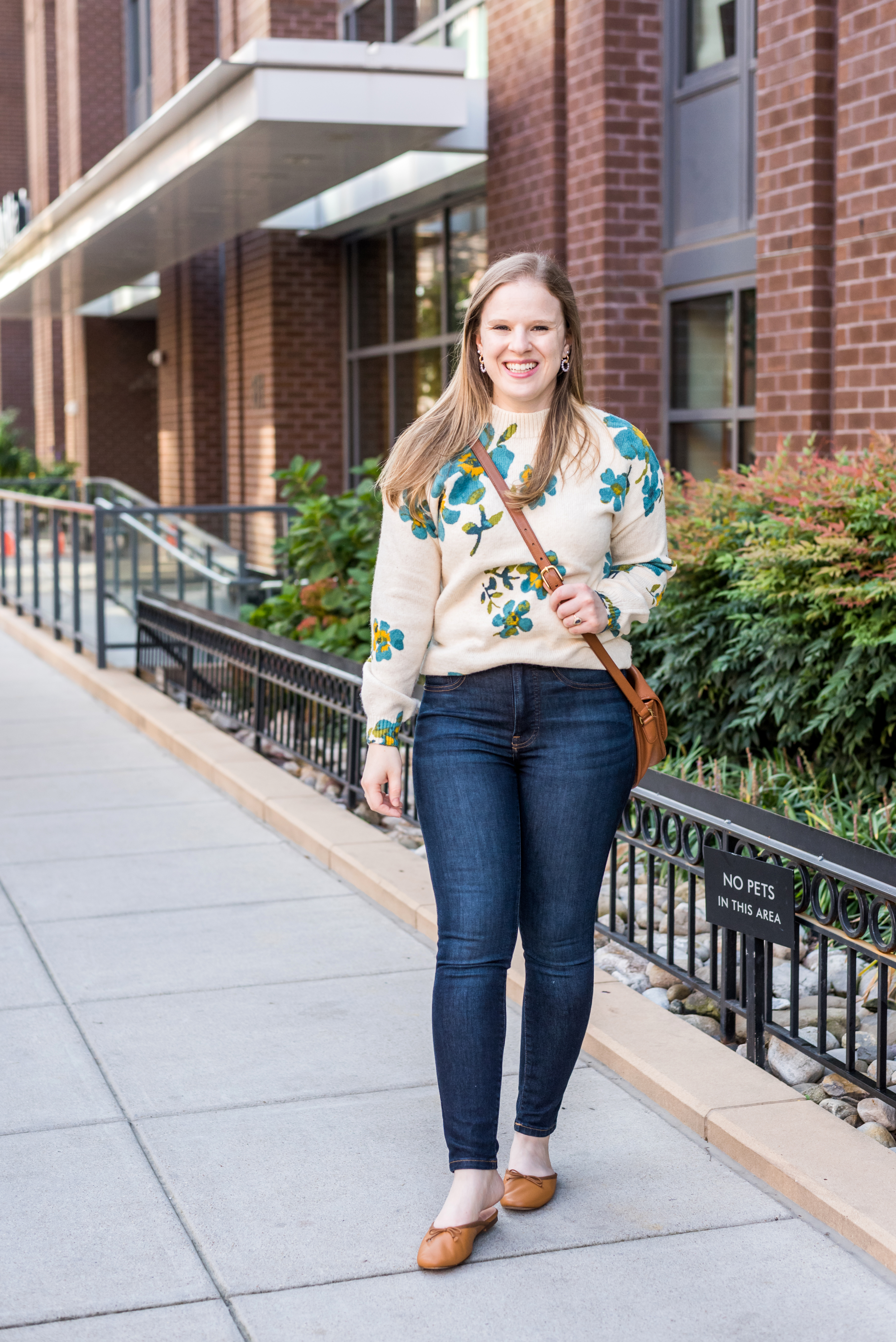 woman wearing loft floral sweater, jeans, and mules woman wearing loft floral sweater, jeans, and mules
